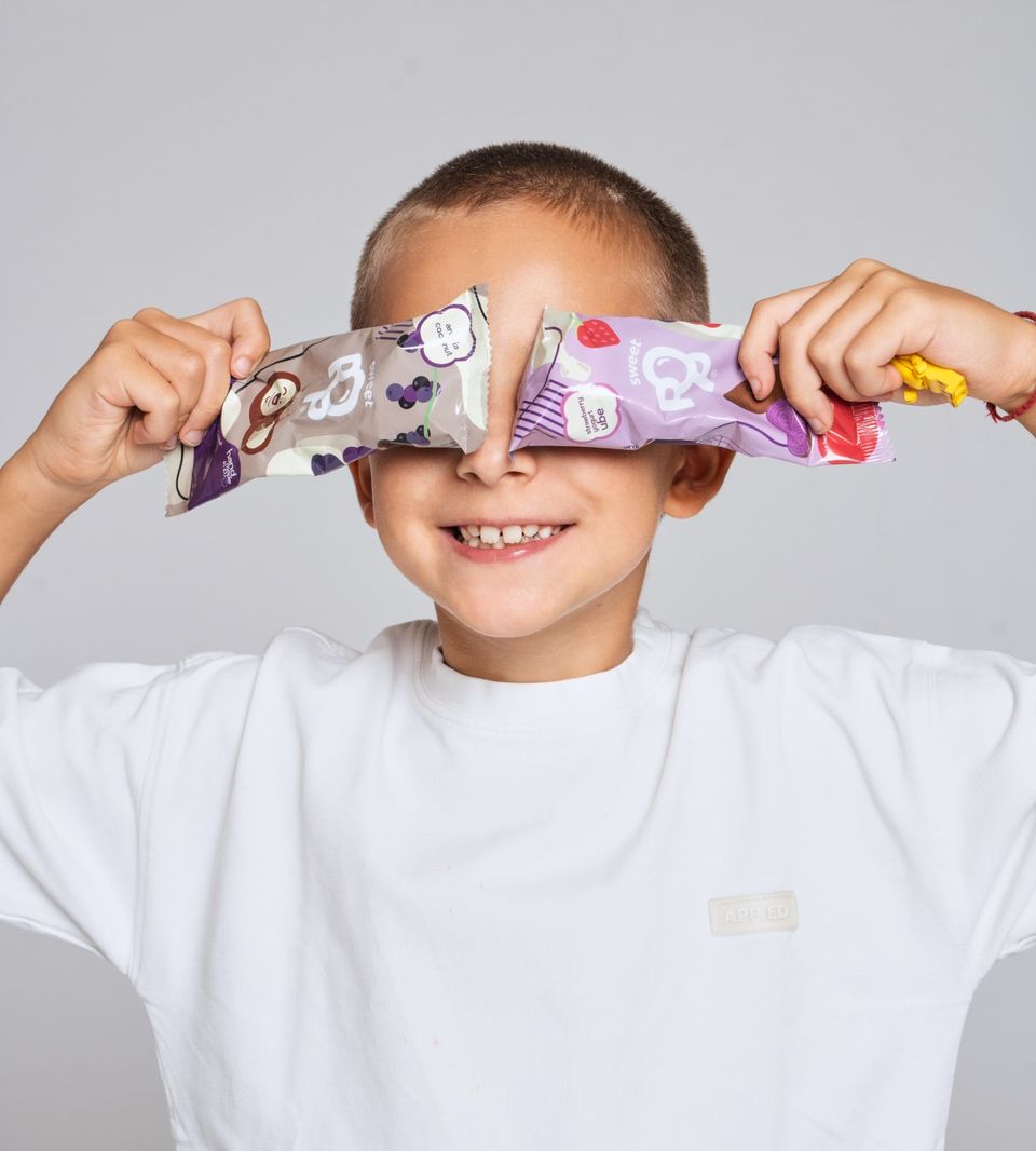 Chlapec si zakrýva oči lízatkami Sweet Pop